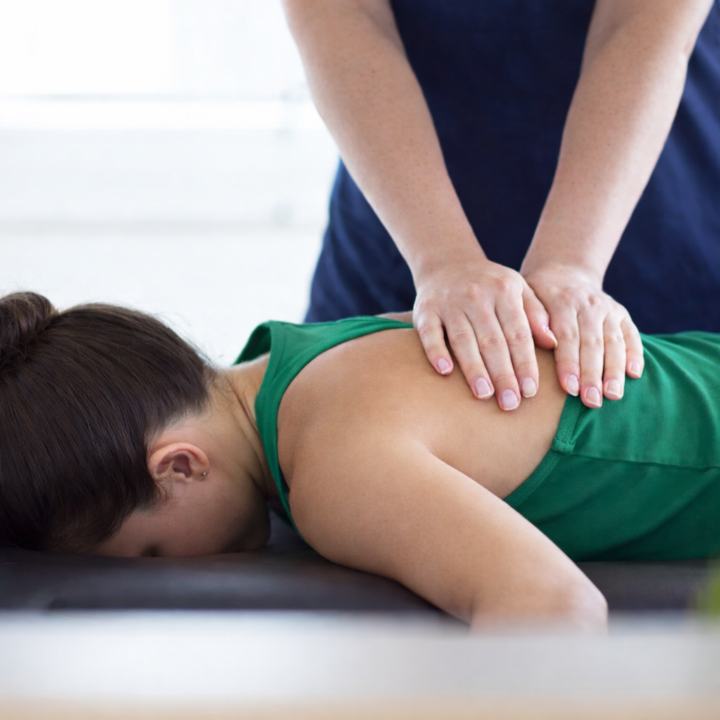 Dr. Shelton performing spinal adjustment on patient for mid back pain after car accident in Plano, TX.