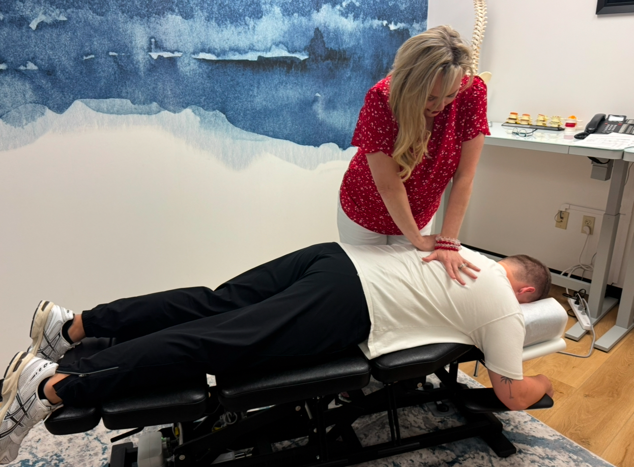 Chiropractor Dr. Melissa Shelton performing a gentle low back adjustment on a patient in her Plano office.